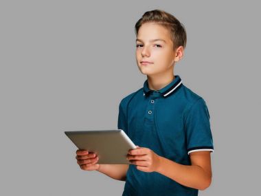 Pozitif genç çocuk tablet Pc tutar.