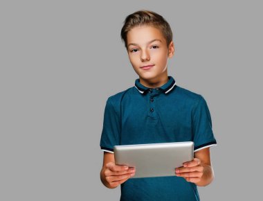 Pozitif genç çocuk tablet Pc tutar.
