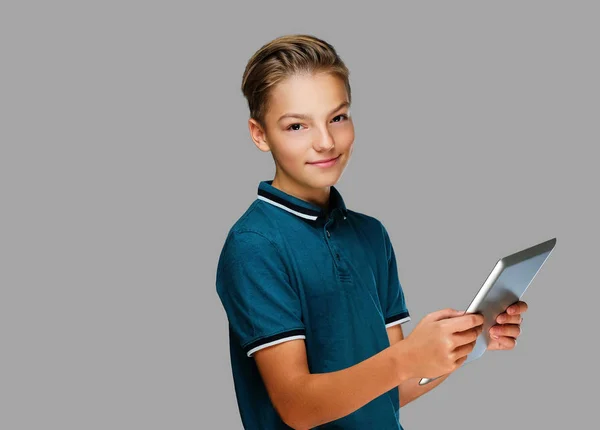 Den positiva tonåring pojken håller tablet Pc. — Stockfoto