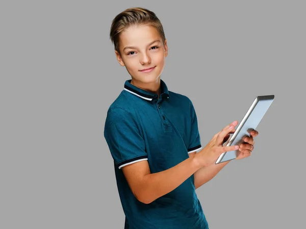 Den positiva tonåring pojken håller tablet Pc. — Stockfoto