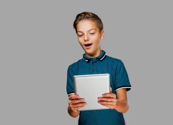 The positive teenager boy holds tablet PC. — Stock Photo, Image