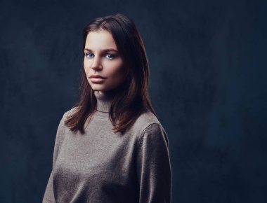 Bir uzun boyunlu kahverengi ceket giymiş bir kadın.