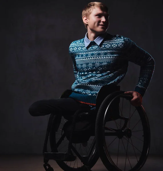 Um homem em cadeira de rodas sobre fundo cinza . — Fotografia de Stock