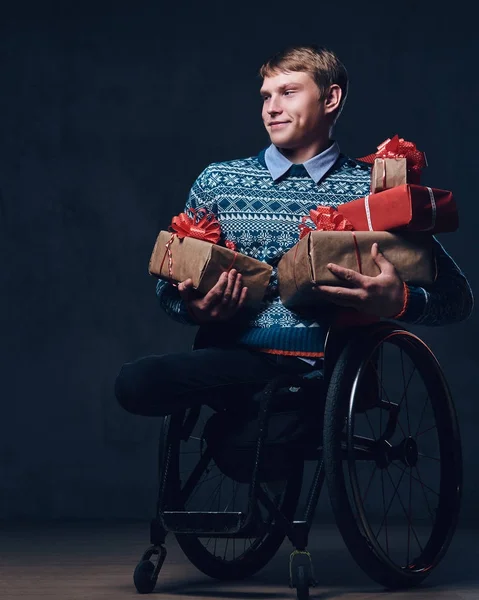 A man in wheelchair with Christmas gifts.