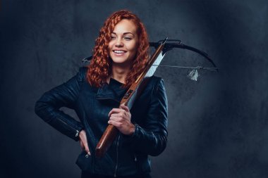 Kızıl saçlı erkek tatar yayı tutar.