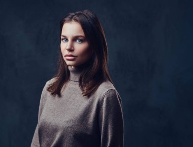 Bir uzun boyunlu kahverengi ceket giymiş bir kadın.