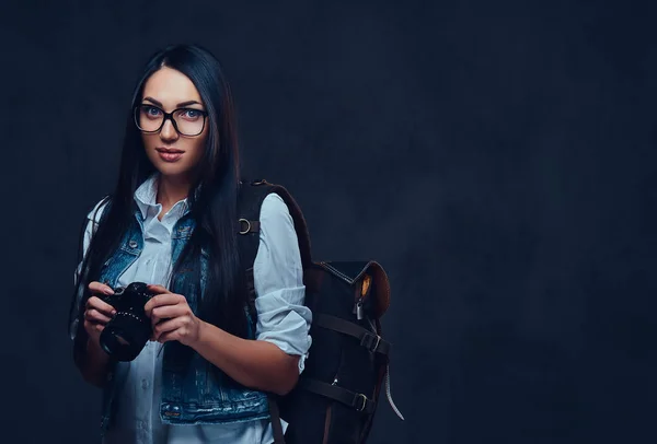 Eine Frau mit Rucksack hält kompakte Fotokamera in der Hand. — Stockfoto