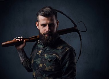 Tatar yayı bir askeri ceket giymiş bir adam tutar.