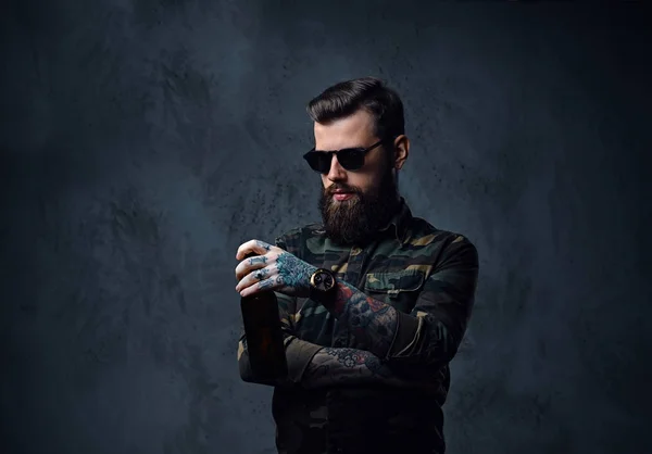 Een man gekleed in militaire shirt, drankjes ambachtelijke bier. — Stockfoto