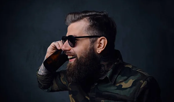 Un hombre vestido con camisa militar, bebe cerveza artesanal . —  Fotos de Stock