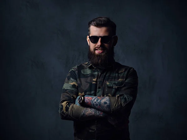 Retrato de un hombre hipster tatuado barbudo vestido de militar — Foto de Stock