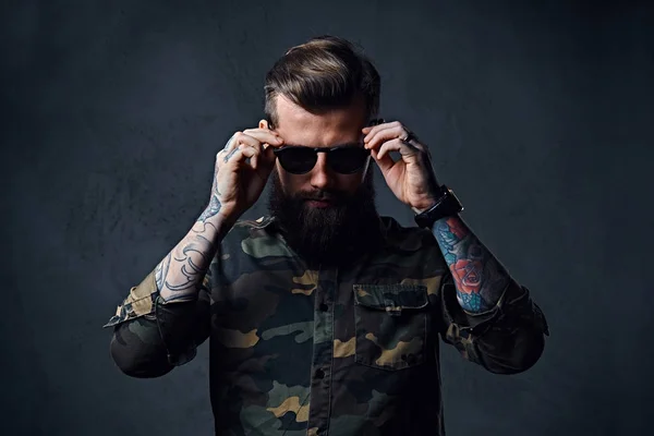 Retrato de un hombre hipster tatuado barbudo vestido de militar —  Fotos de Stock