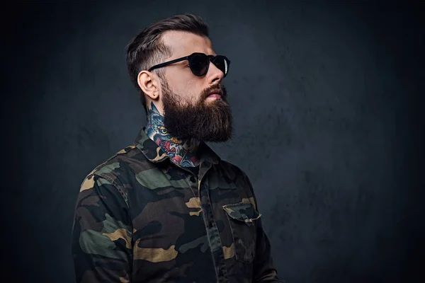 Retrato de un hombre hipster tatuado barbudo vestido de militar — Foto de Stock