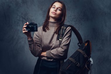 Esmer bir kadın kompakt fotoğraf makinesi tutar