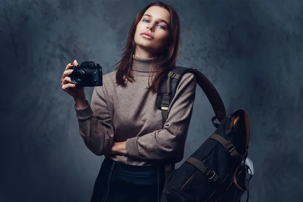 Een brunette vrouw houdt compacte fotocamera — Stockfoto