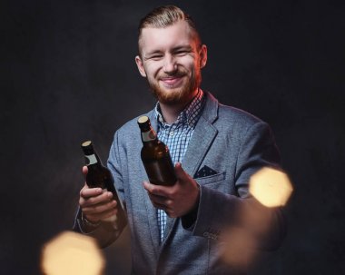 Şık sakallı adam bira tutar 