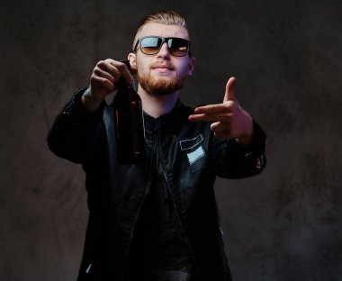 Erkek zanaat bira şişesiyle tutar.