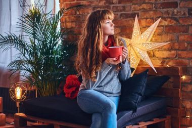 Kızıl saçlı kadın sıcak bir kahve içer 