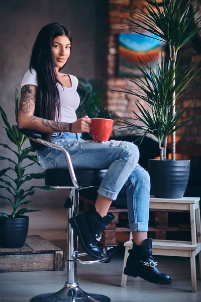 Tatuerade brunett kvinnlig drycker kaffe — Stockfoto