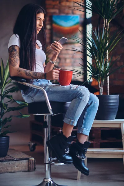 Татуированная брюнетка женщина пьет кофе — стоковое фото