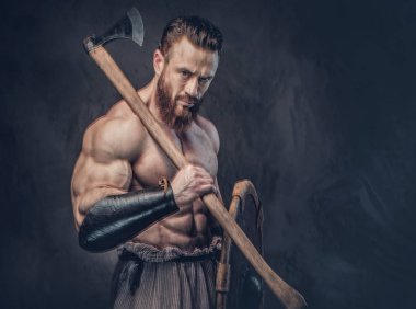 Sanatsal portre gömleksiz büyük kas Viking baltası koyu gri arka plan üzerinde tutar..