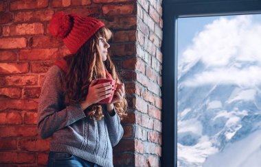 Kızıl saçlı kadın kahve tutar 