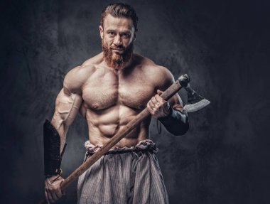 Sanatsal portre gömleksiz büyük kas Viking baltası koyu gri arka plan üzerinde tutar..