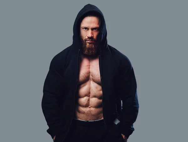 Brutal Bearded Bodybuilder Dressed Black Jacket Hood Isolated Grey Background — Stock Photo, Image