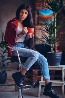 Dövmeli esmer kadın sıcak kahve içer
