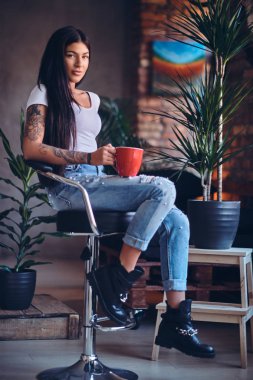 Dövmeli esmer kadın sıcak kahve içer