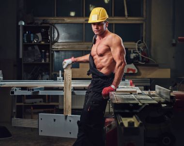 Portre gömleksiz kas marangoz bir atölye.