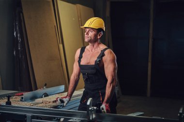 Portre gömleksiz kas marangoz bir atölye.