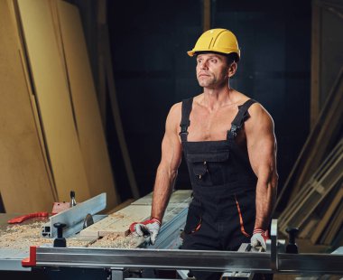 Portre gömleksiz kas marangoz bir atölye.