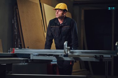 Woodworker tahta masada yaslanmış.