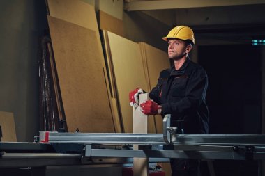 Woodworker tahta masada yaslanmış.