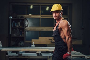 Portre gömleksiz kas marangoz bir atölye.