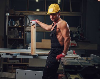 Portre gömleksiz kas marangoz bir atölye.