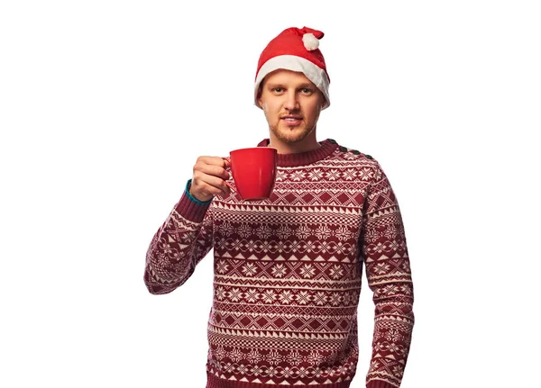 サンタの帽子で魅力的な男性の肖像画は 大きな赤いカップにコーヒーを保持します 白い背景に分離 — ストック写真