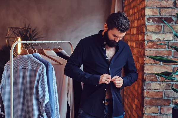 Een man die passen op trendy shirts. — Stockfoto