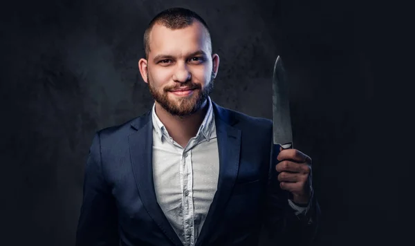 Un hombre de traje sostiene un cuchillo de chef. . — Foto de Stock