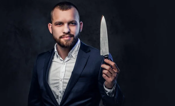 Un hombre de traje sostiene un cuchillo de chef. . — Foto de Stock