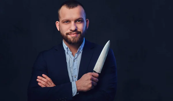 Un hombre de traje sostiene un cuchillo de chef. . — Foto de Stock