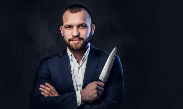 A man in a suit holds a Chef's knife. — Stock Photo, Image