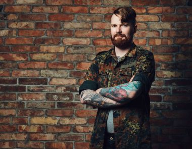 Bir tuğla duvarın üzerinden Kızıl saçlı erkek.