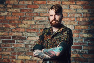 Bir tuğla duvarın üzerinden Kızıl saçlı erkek.