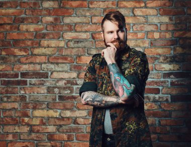 Bir tuğla duvarın üzerinden Kızıl saçlı erkek.