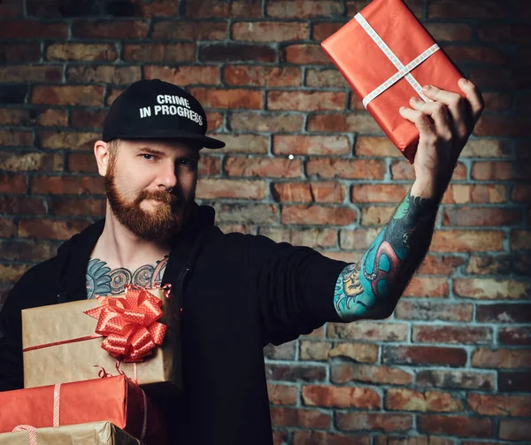 Позитивный Рыжий Мужчина Держит Рождественские Подарки Стене Кирпича — стоковое фото