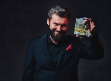 Takım elbiseli sakallı erkek euro banknot tutar.
