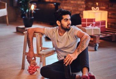 Çekici Hintli erkek içecekler zanaat bira Noel dekorasyonu ile bir odada sakallı.