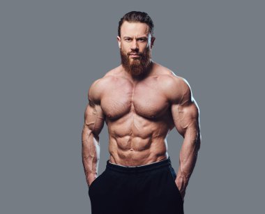 Sakallı gömleksiz vücut geliştirmeci gri arka plan üzerinde portresi.